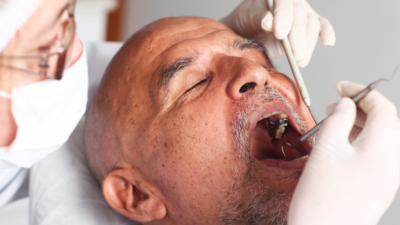 Elderly man having an oral hygiene check-up at dentist.